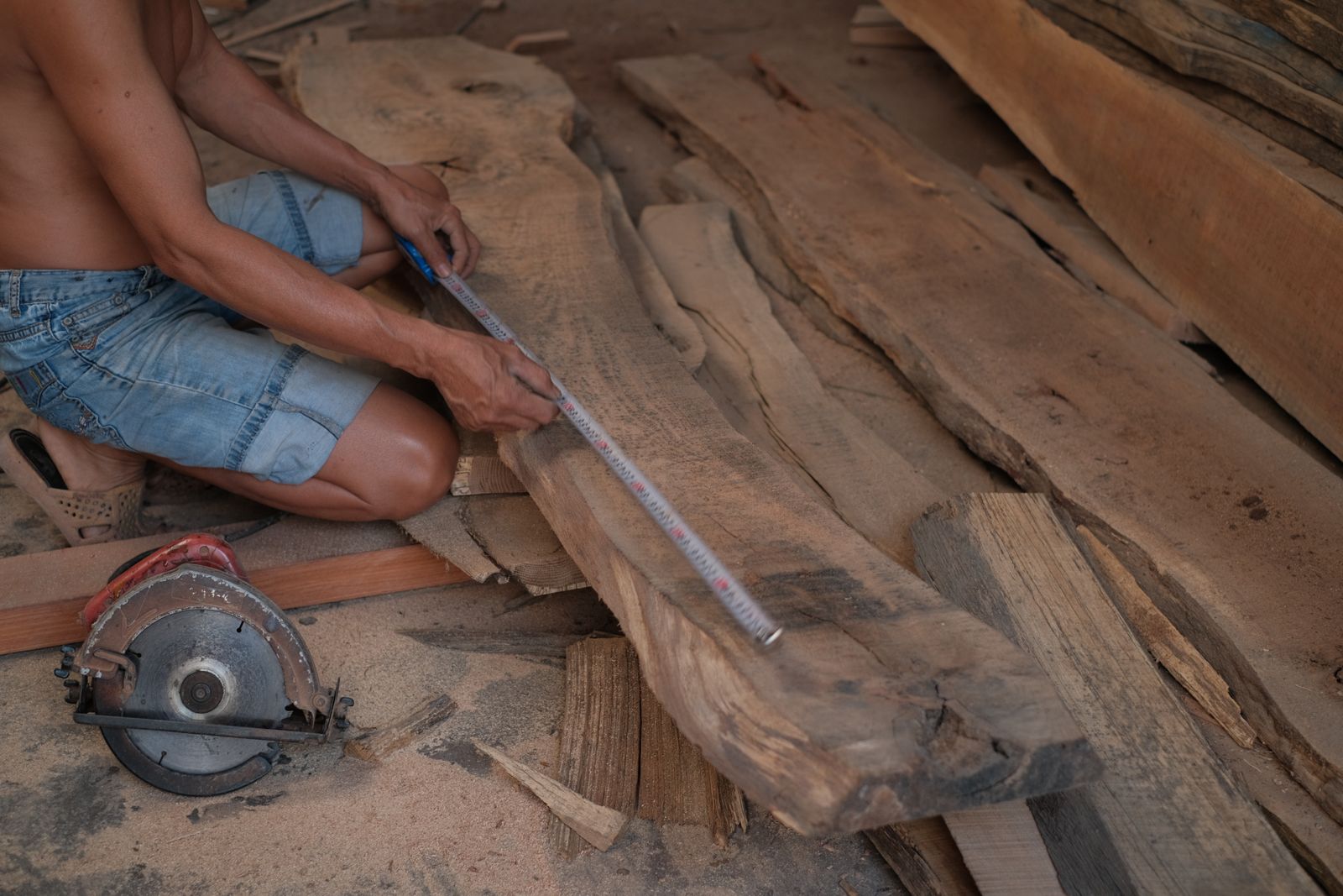 Carpenter measuring a wooden plank in a workshop — practical AI applied to the parts of the fitout workflow where precision and prediction matter