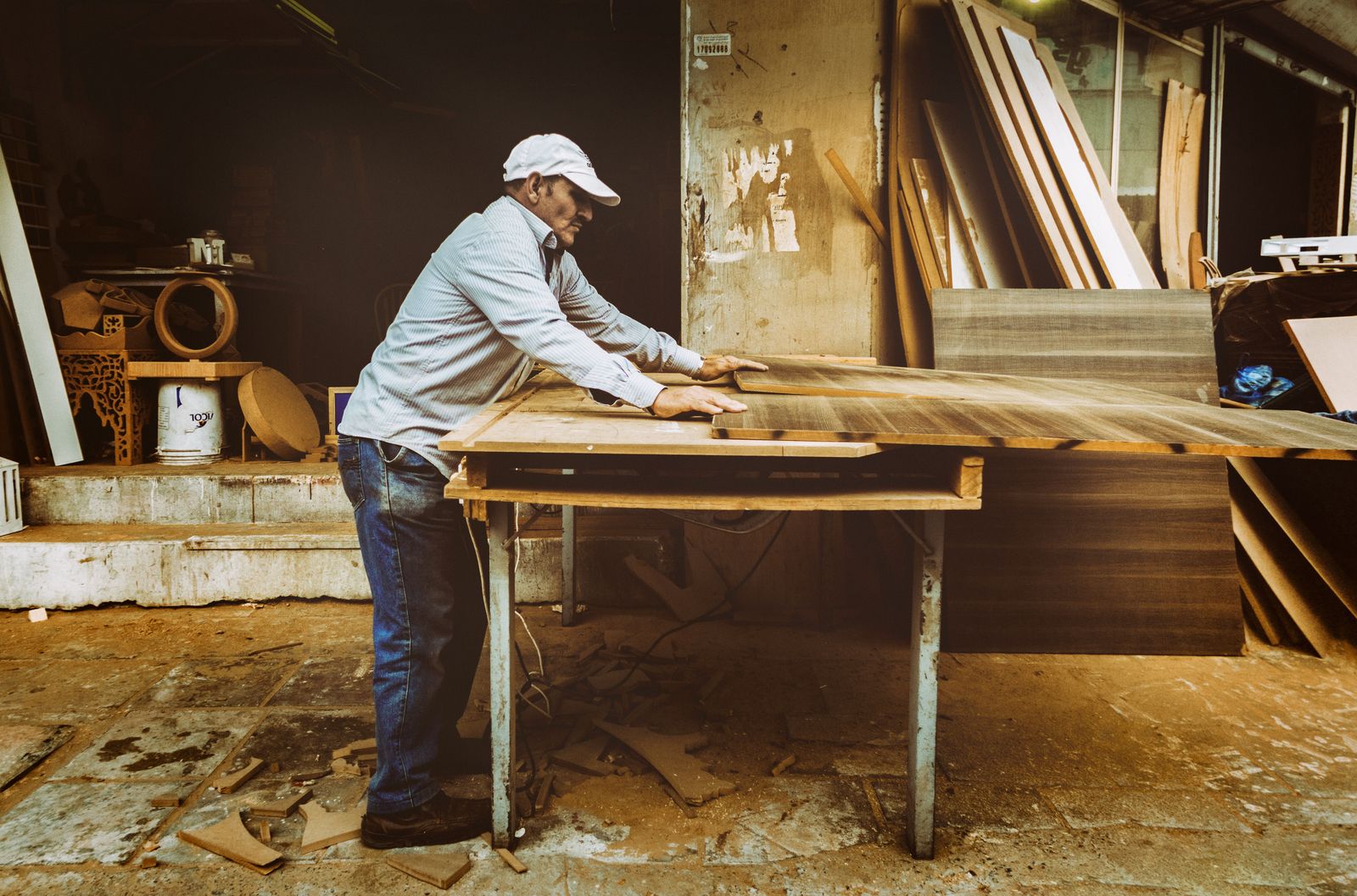 Carpenter cutting timber in workshop — the precision of the work rarely matches the messiness of the handover documentation that follows
