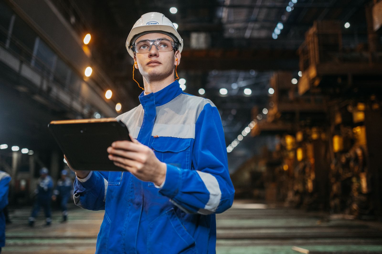 Electrical engineer reviewing live job data on a tablet — practical AI assisting field and office decisions