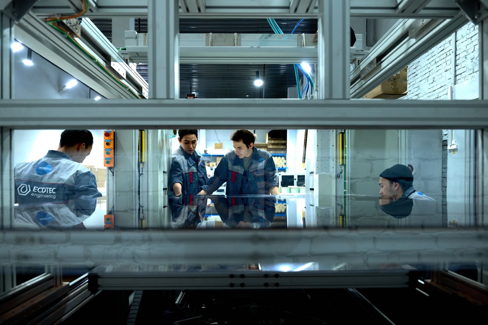 Engineers collaborating around machinery — automation that runs the repeatable parts of an electrical operation so the team focuses on the work