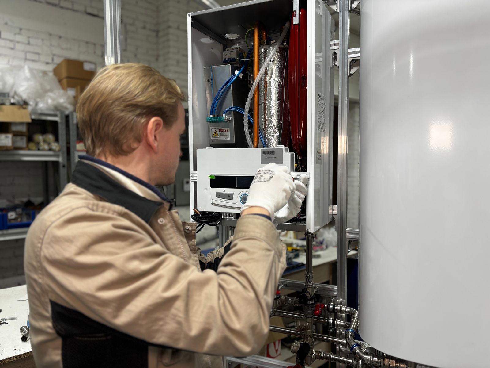 Gas technician servicing a heating system — combustion analyser readings taken on this job rarely make it back to the asset record