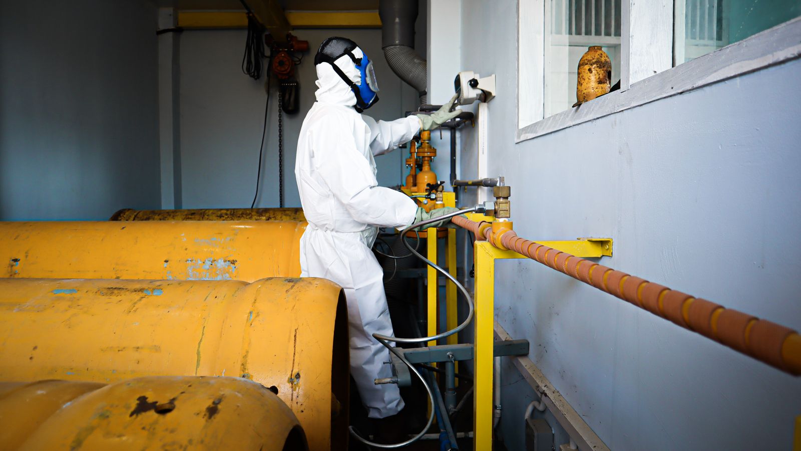 Gasfitter in protective gear working with pipework — practical AI applied to combustion data and asset history