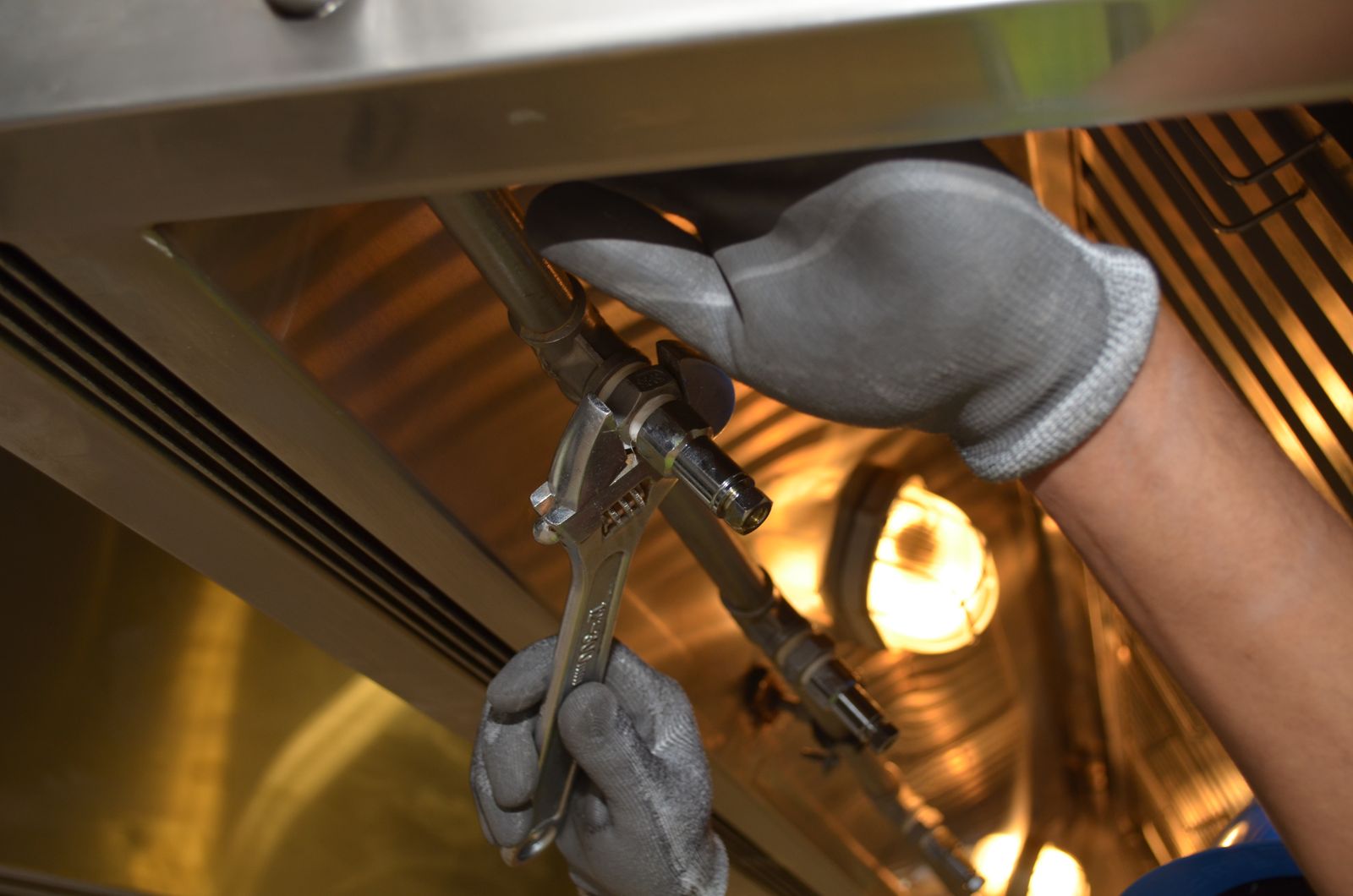 Plumber tightening pipework with a spanner — automation that runs the repeatable parts of the operation so the team focuses on the work